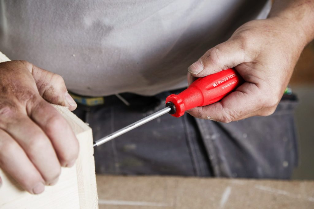 Eine Person benutzt einen Schraubenzieher zum Bauen.